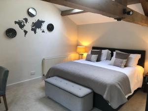 a bedroom with a large bed and clocks on the wall at The Old Vicarage, Evenley. Brackley. in Brackley