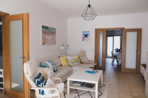 ein Wohnzimmer mit Sofa und Tisch in der Unterkunft Beautiful 3 bedroom Villa in Torre Comporta I in Comporta