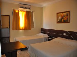 En eller flere senge i et værelse på Real Hotel Empreendimentos