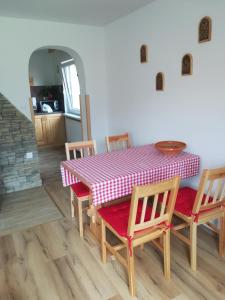 mesa de comedor con mantel a cuadros rojo y blanco en Apartma pr´ Štengarju, en Bohinjska Bela