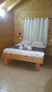 un letto in legno con due orsacchiotti seduti sopra di Chalet The Mountain To The Sea a Beẕet