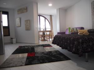 プラヤ・デ・ラス・アメリカスにあるPARQUE SANTIAGO - PLAYA LAS AMERICASのベッドルーム1室(ベッド1台、ソファ、ラグ付)