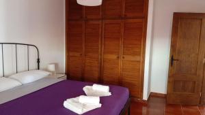 Un dormitorio con una cama morada con toallas. en Vista Guapa, en La Frontera