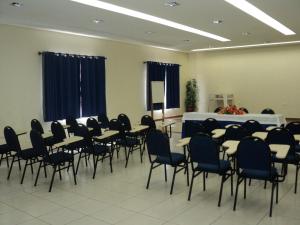 uma sala com cadeiras e mesas e um pódio em Real Hotel Empreendimentos em São Raimundo Nonato