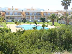 a view of a resort with a pool and palm trees at Apartamento Casas del Mar in Oliva