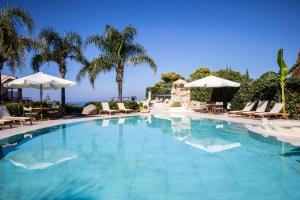 uma grande piscina com cadeiras e guarda-sóis em L' Arcobaleno Resort em Capo Vaticano