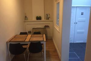 een eetkamer met een tafel en stoelen en een deur bij Cosy little house in Brugge
