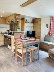 een keuken en een woonkamer met een tafel en stoelen bij Mobil home excellence le lac des rêves 4* LATTES in Lattes