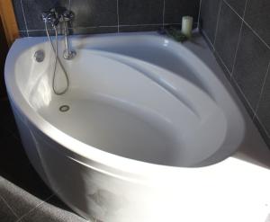 a white bath tub sitting in a bathroom at SENTIR VIC in Vic