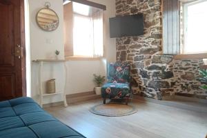 sala de estar con silla y pared de piedra en My Historic House 2, en Bragança