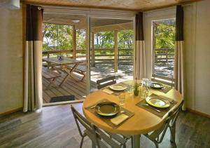 een eetkamer met een tafel en stoelen en een patio bij Camping San Damiano in Biguglia