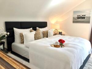 a white bed with a plate of flowers on it at RS Apartment Baden-Baden in Baden-Baden