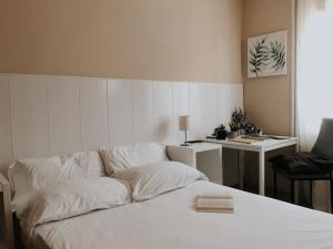 a white bed in a room with a desk at Metropolitan Atocha in Madrid
