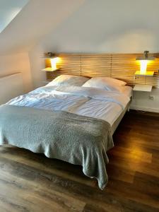 a bedroom with a large bed with a wooden headboard at Apartament z balkonem blisko plaży in Niechorze