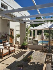 a patio with a white pergola and a pool at The Whitehouse in Barrydale