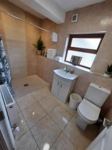 a bathroom with a toilet and a sink and a window at Lovely ballina townhouse in Ballina