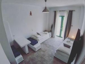 una sala de estar con 2 sofás blancos y una ventana en Filio Guesthouse, en Kipri