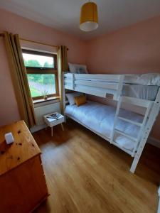 1 dormitorio con 2 literas y ventana en Lovely ballina townhouse, en Ballina