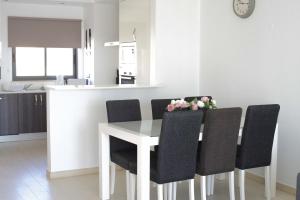 a kitchen and dining room with a white table and chairs at Albur Village in Alvor