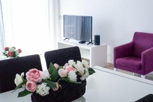 een woonkamer met 2 stoelen en een tafel met bloemen bij Albur Village in Alvor