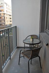 a small table and two chairs on a balcony at Unique apt EVE - free garage in Krakow