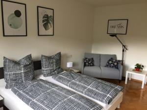 ein Bett mit schwarzen und weißen Kissen im Wohnzimmer in der Unterkunft Auszeit in Ettenheim