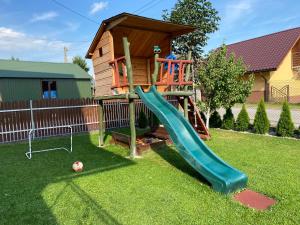 un parque infantil con un tobogán junto a una casa en Apartamenty w Maniowach, en Maniowy