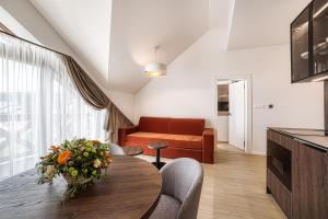 a living room with a table and a couch at Apartment Tiliana in Vysoke Tatry - Tatranska Lomnica.