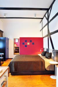 a bedroom with a large bed and a red wall at Suite „Herrenhausen“ - stilvolles Apartment in Fachwerkhaus in Hannover