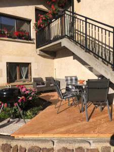 eine Terrasse mit Stühlen, einem Grill und einem Balkon in der Unterkunft Les chambres du Moulin in Les Epsailles