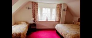 Dalmellington的住宿－Forget Me Not Holiday Cottage，一间卧室设有两张床和窗户。
