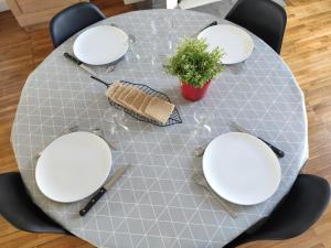 a table with white plates and a plant on it at Appartement 1-6 pers situé entre les ponts in Saumur +13 photos