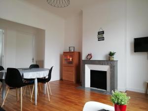 a living room with a table and a fireplace at Appartement 1-6 pers situé entre les ponts in Saumur