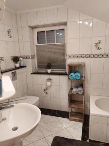 a bathroom with a sink and a toilet and a window at Haus Rodriguez in Baesweiler +15 photos