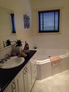 a bathroom with a sink and a bath tub at Salt Air on Banyan in Warrnambool