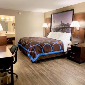 a hotel room with a bed and a desk at Super 8 by Wyndham Cookeville, TN in Cookeville