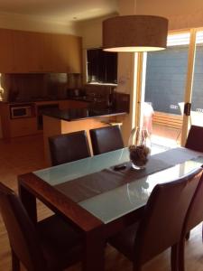 a dining room table with a vase on top of it at Salt Air on Banyan in Warrnambool