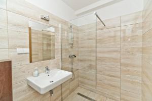a bathroom with a sink and a glass shower at Domki Apartamentowe WIKING in Władysławowo