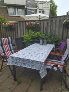 een blauwe en witte tafel met twee stoelen en een paraplu bij Charming Family Home in Delft