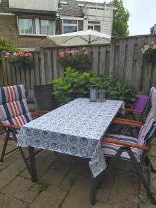 a blue and white table with two chairs and an umbrella at Charming Family Home in Delft
