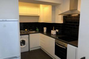 a kitchen with a washing machine and a washer at Fishergate ApartHotel 1 - Stylish City Centre Apartment in Preston