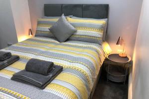 a bedroom with a large bed with towels on it at Fishergate ApartHotel 1 - Stylish City Centre Apartment in Preston