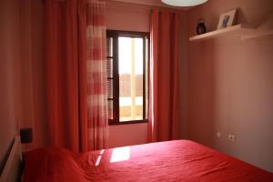 une chambre avec un lit rouge et une fenêtre dans l'établissement Apartamento Katrina Balcón del mar, à Costa del Silencio 27 autres photos
