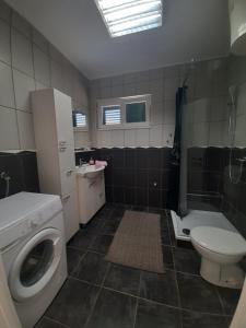 a bathroom with a washing machine and a toilet at Apartment Računica in Vodice +24 photos