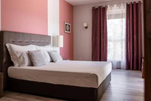 Un dormitorio con una cama con paredes rosas y una ventana en Quinta Ponte da Capinha, en Capinha