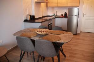 une cuisine avec une table avec des chaises et un réfrigérateur dans l'établissement Apartamento Katrina Balcón del mar, à Costa del Silencio