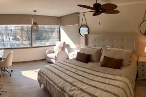 Schlafzimmer mit einem großen Bett und einem Deckenventilator in der Unterkunft Precioso departamento en Los Dominicos in Santiago