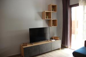 a living room with a flat screen tv on a cabinet at Apartamento Katrina Balcón del mar in Costa Del Silencio