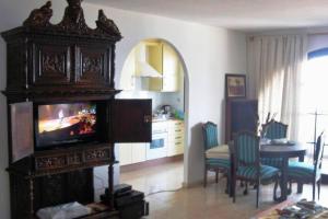 ein Wohnzimmer mit einem TV und einem Esstisch in der Unterkunft Casa Rosita in Agaete