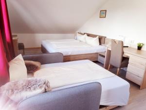 a room with two beds and a desk and a chair at Hotel Oyer Hof - selbst Service in Oy-Mittelberg